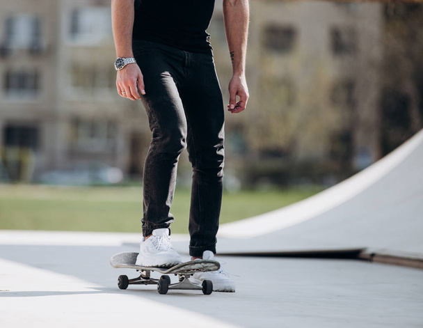The man rides skateboard on a platform outside next to the house at the sunny warm day - Valokuva, kuva