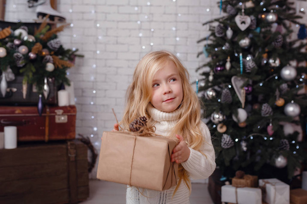 kleines stylisches Mädchen posiert in der Nähe des Neujahrsbaums - Foto, Bild