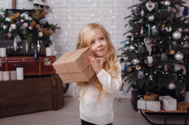 Маленькая стильная девушка позирует возле новогодней елки
 - Фото, изображение