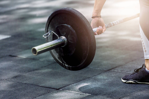 Кроссфит женщина готовится к тяжелой атлетике тренировки с тяжелым гантели
 - Фото, изображение