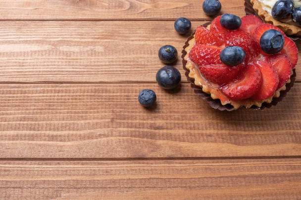 fruit tartlets on a wooden plate on the table, fruit baked shell - Photo, Image