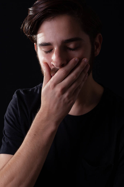 Закрыть молодые взрослые мужские глаза закрыв руку над ртом в шоке или ужасе от сделанных действий и исхода. Концепция бедствия после домашнего насилия
 - Фото, изображение