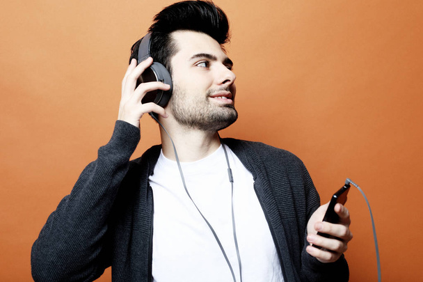 lifestyle, technology and people concept: Happy young man smiling listening to music in headphones. - Photo, image