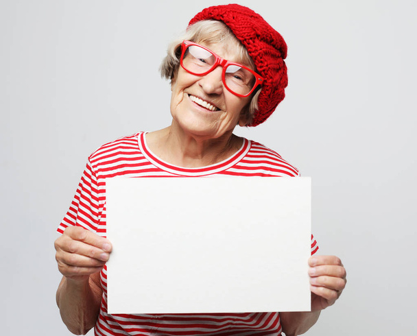 Portrait of happy senior woman with blank advertising board or copy space - Φωτογραφία, εικόνα