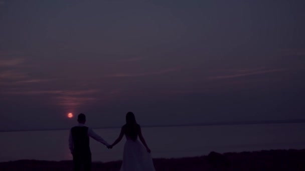 Liebespaar - junger Bräutigam und schöne Braut bei Sonnenuntergang - Filmmaterial, Video