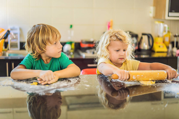 Two children a boy and a girl make cookies from dough - Fotoğraf, Görsel