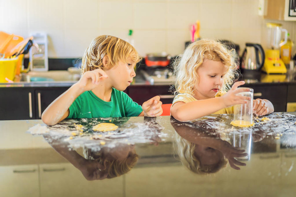 Deux enfants un garçon et une fille font des biscuits avec de la pâte
 - Photo, image