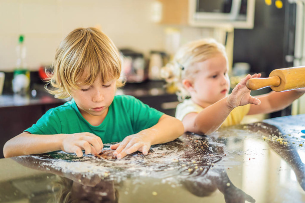 Two children a boy and a girl make cookies from dough - Zdjęcie, obraz