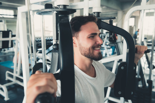 Przystojny mężczyzna jest wykonywanie z maszyny do piersiowych, w Fitness klubie., portret z Strong Man robi pracy się kalorie spalanie w Gym., zdrowe i Fitness Lifestyle Concept. - Zdjęcie, obraz