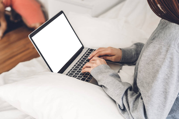Mujer joven que se relaja con el ordenador portátil en el bedroom.woman
  - Foto, Imagen