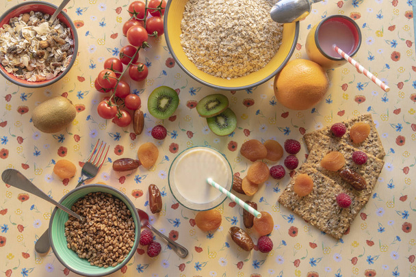 Uve, kiwi, prugne secche e cereali da colazione con latte
 - Foto, immagini