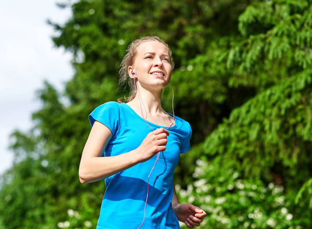 Young fitness woman running at forest trail. - Foto, imagen
