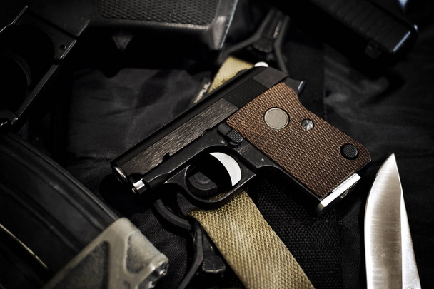 Mały pistolet ukryty, mini pistolet kompaktowy dla kobiety na czarnym tle, zbliżenie broni i sprzętu wojskowego dla armii. - Zdjęcie, obraz