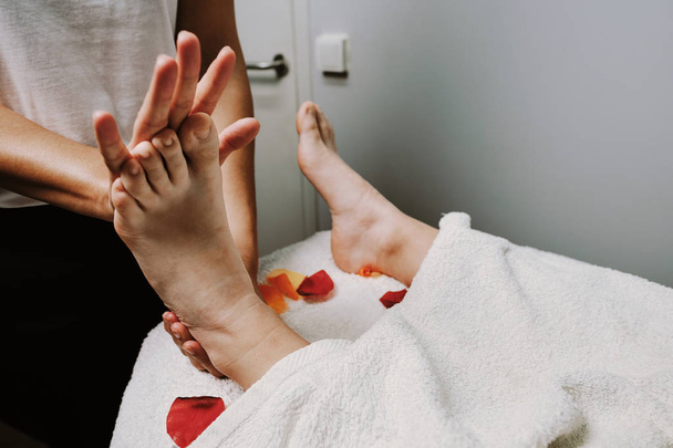 Μεγέθυνση του γυναικεία χέρια κάνει μασάζ στα πόδια - Φωτογραφία, εικόνα