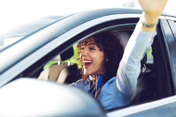 Young beautiful smiling girl driving a car  - Фото, изображение