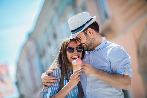 幸せなカップルの日付を持つと、ショッピングの後にアイスクリームを食べる - 写真・画像