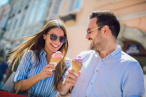 Ευτυχισμένο ζευγάρι έχει ημερομηνία και τρώγοντας παγωτό μετά τις αγορές σας - Φωτογραφία, εικόνα