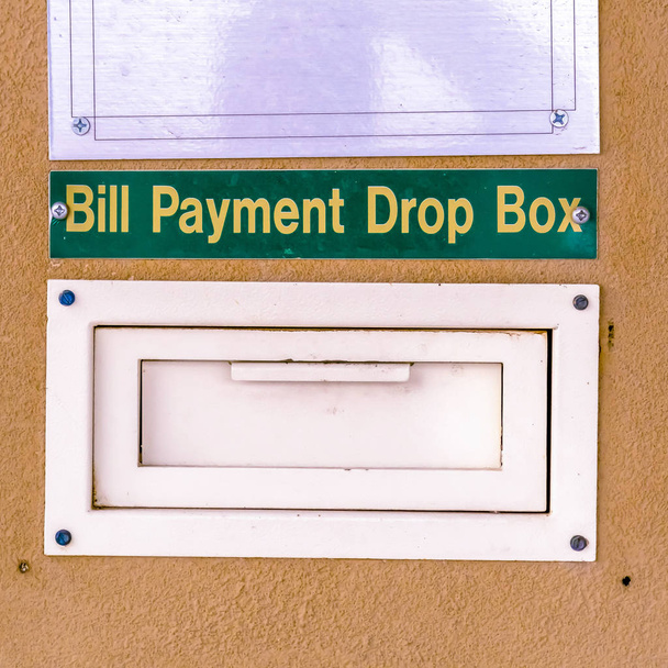 Caixa de entrega de pagamento de conta quadrada em uma parede para residentes ou empresas pagarem suas contas
 - Foto, Imagem