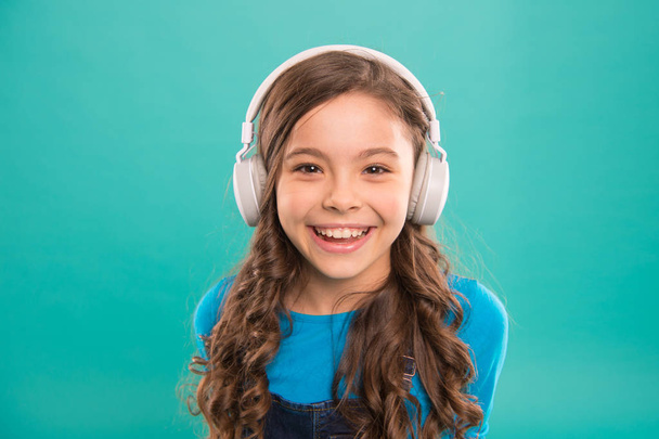 Online education. Girl adorable child listening audio course. Get more information. Audio book. Modern education concept. Benefits audio lessons. Access to knowledge. Audio track. Schoolgirl leisure - Foto, Imagen