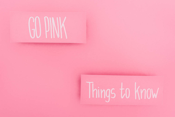 vista superior de cartões com coisas para saber e ir lettering rosa no fundo rosa, conceito de câncer de mama
 - Foto, Imagem
