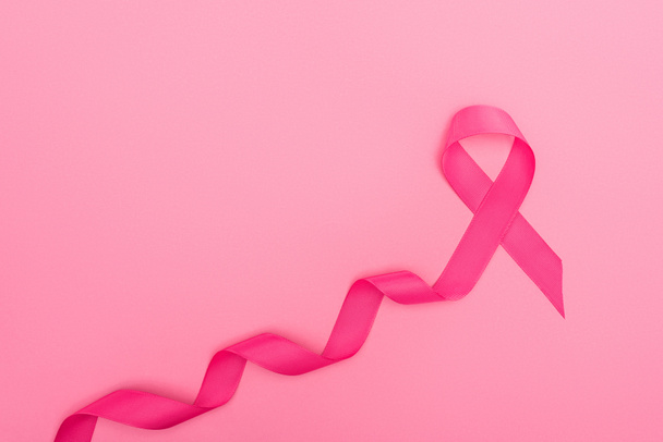 top view of curved crimson breast cancer sign on pink background - Фото, зображення