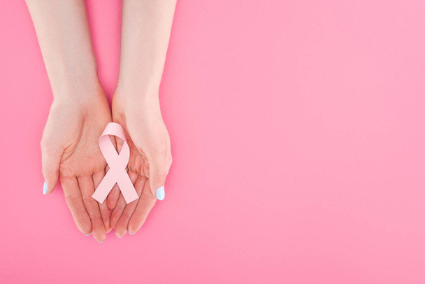 partial view of woman with pink breast cancer sign on pink background with copy space - Фото, изображение
