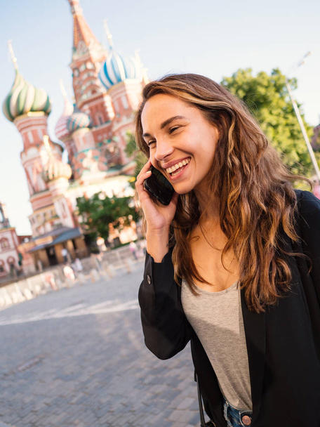 Smiling young woman portrait talking ath the phone in Red Square - Zdjęcie, obraz