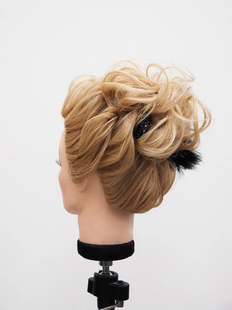 Európai frizura a fejen egy manöken egy világos háttér - Fotó, kép