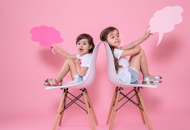 deux filles sur un fond coloré avec des icônes de la parole
 - Photo, image
