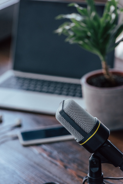 selective focus of microphone near laptop and smartphone with blank screen on wooden table - Photo, Image