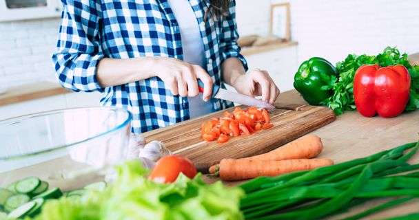 Female hands cutting vegetables in the kitchen. Woman cooking healthy food. Fresh vegetables on the cutting board. Concept of cooking. Diet. Healthy and vegan lifestyle. Cooking at home. Prepare food - Fotoğraf, Görsel