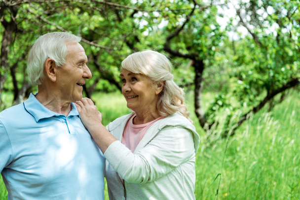 cheerful retired man looking at happy wife in green park  - Φωτογραφία, εικόνα