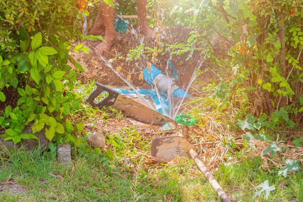 сломанная труба в отверстии и движение воды при ремонте придорожного водопроводчика
 - Фото, изображение