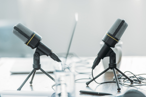 selective focus of two microphones on wooden table in broadcasting studio - Fotografie, Obrázek