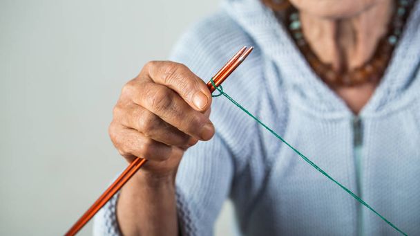 編み物用のウール糸。老婦人の手編みの写真を閉じます。年金受給者の趣味。甘い成熟し、興味深いレジャー。祖母と家族。孤独と無力 - 写真・画像