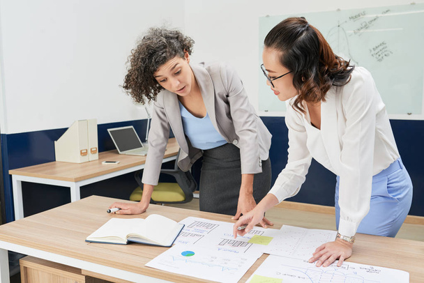 Багатонаціональні жінки-працівниці обговорюють фінансові графіки на зустрічі
 - Фото, зображення