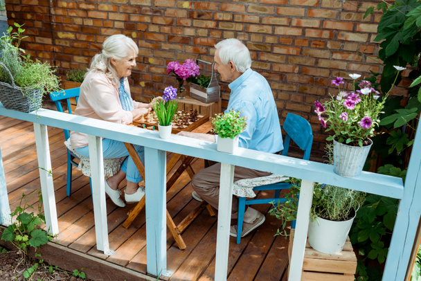 felice coppia in pensione giocare a scacchi mentre seduto sulla terrazza
  - Foto, immagini