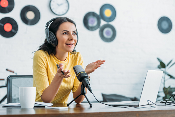 smiling radio host gesturing while recording podcast in broadcasting studio - Φωτογραφία, εικόνα