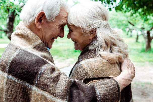 feliz anciano mujer y hombre en mantas mirando el uno al otro
  - Foto, Imagen