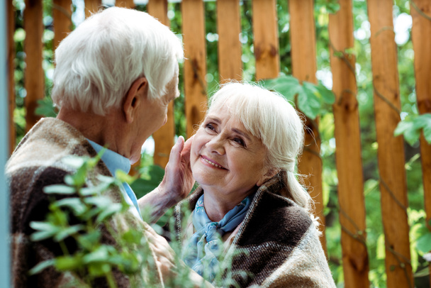 foco seletivo do homem idoso com cabelos grisalhos tocando o rosto da esposa aposentada
 - Foto, Imagem