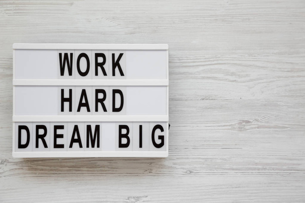"Εργασία σκληρά όνειρα μεγάλες" λέξεις σε ένα φωτεινό κουτί σε ένα λευκό ξύλινο σέρφινγκ - Φωτογραφία, εικόνα