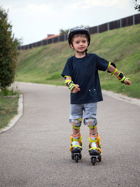 Young boy having fun on roller skates outdoors in summer time. - Foto, Imagen