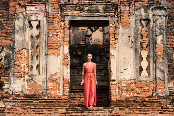 Young woman dancing in front of traditional Temple in Ayutthaya, Thailand - Photo, Image