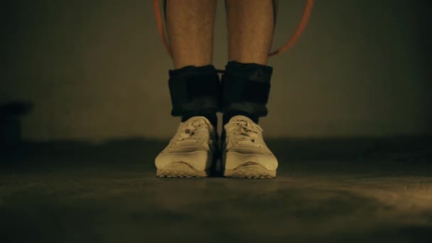 Legs wearing white colored sports shoes and black colored ankle weights and doing  skipping exercise. - Séquence, vidéo