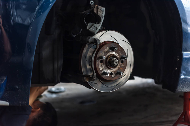 Дисковый тормоз и асбест тормозные колодки в гараже автомобиля
 - Фото, изображение