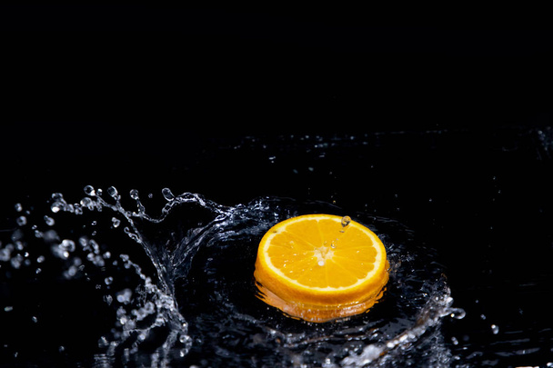 orange splash on black background - Foto, Bild