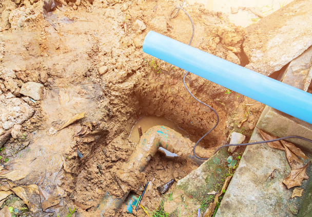 сломанная труба в отверстии с движением воды на придорожном ремонте
 - Фото, изображение