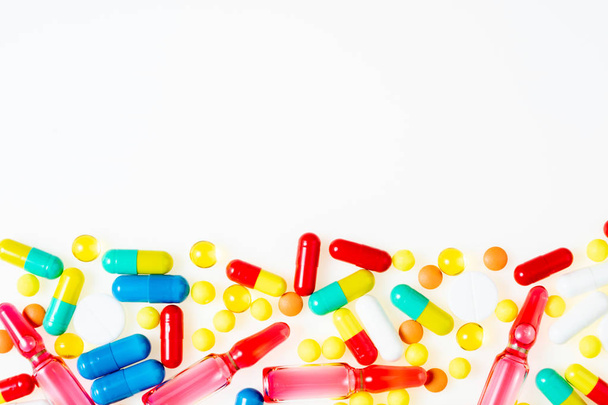 Ассорти лекарственных препаратов таблетки, таблетки, ампулы и капсулы на белом фоне вид сверху. Медицинский опыт. Плоский лежал
 - Фото, изображение