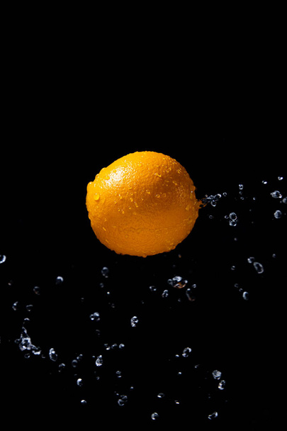 orange splash on black background - Φωτογραφία, εικόνα