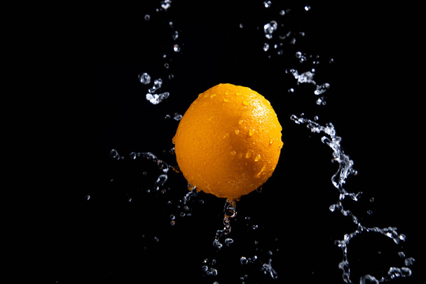 orange splash on black background - Foto, Imagem